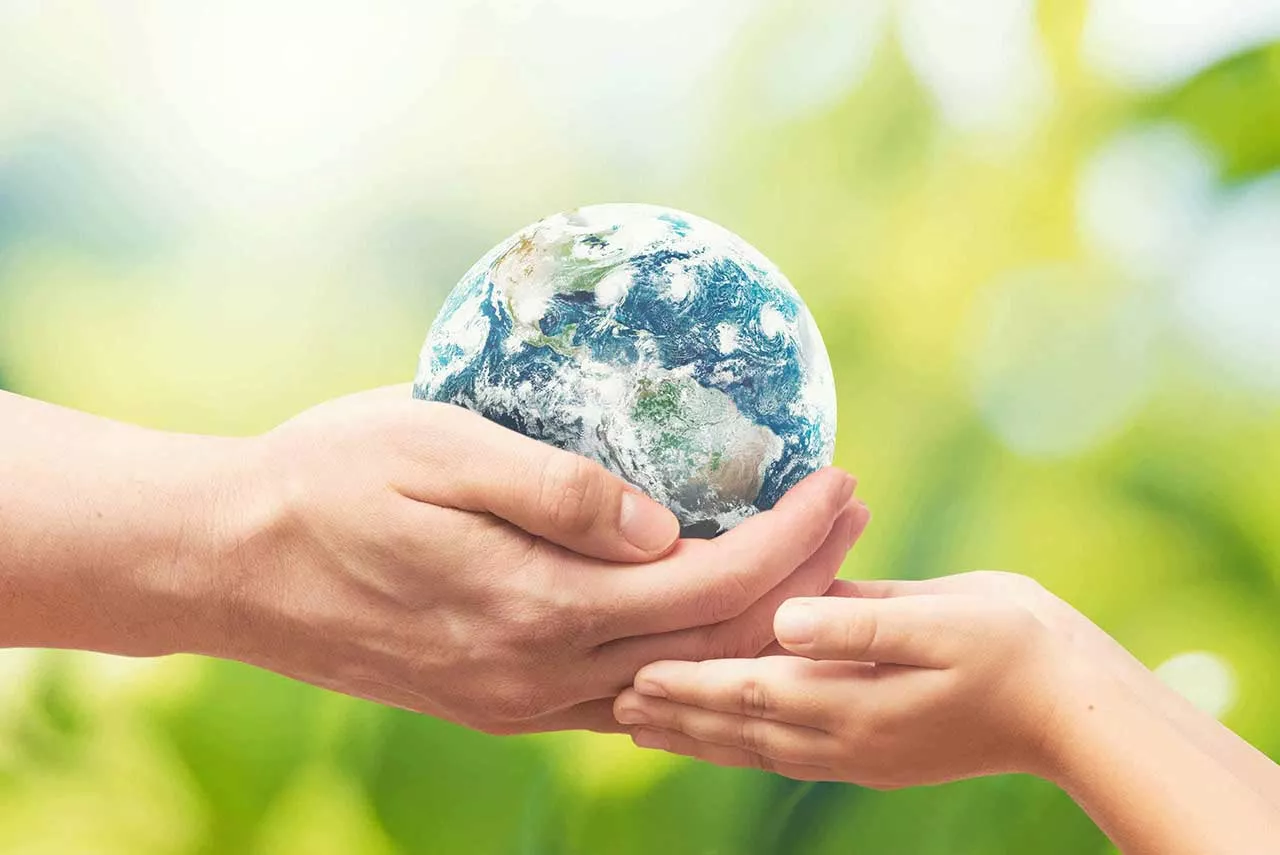 Corporate social responsibility. A man is handing a miniature Earth to a child